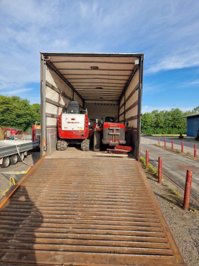 Lastbil læsset med byggeudstyr og maskiner