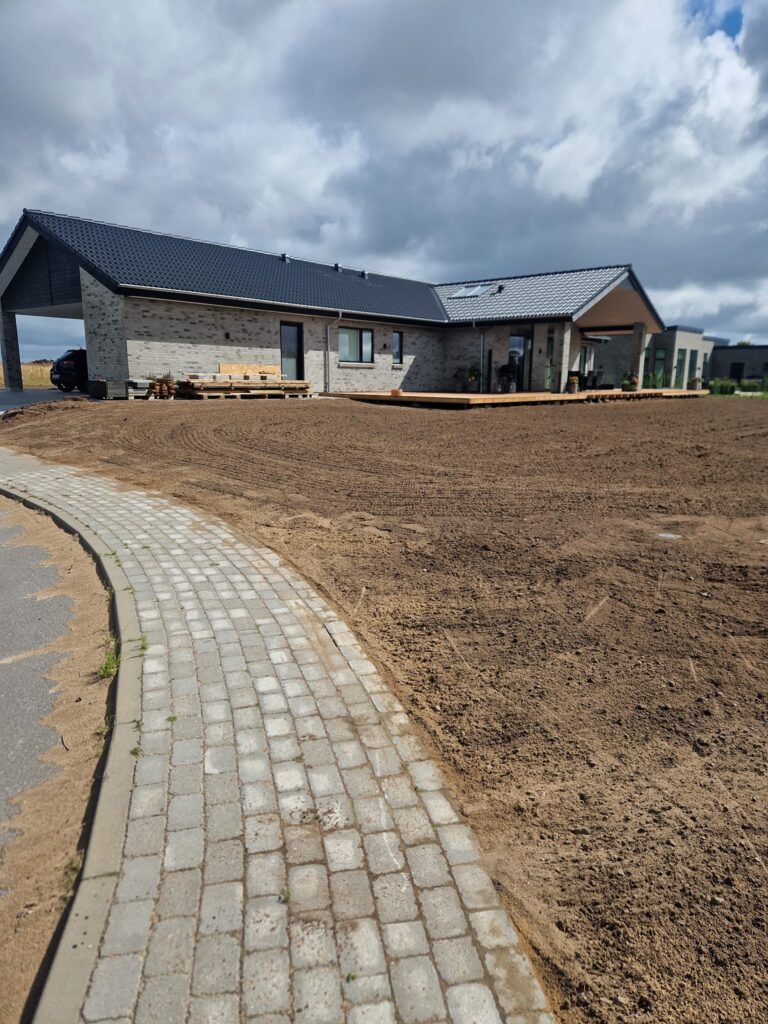 Nybygget hus med gårdhave og jord foran